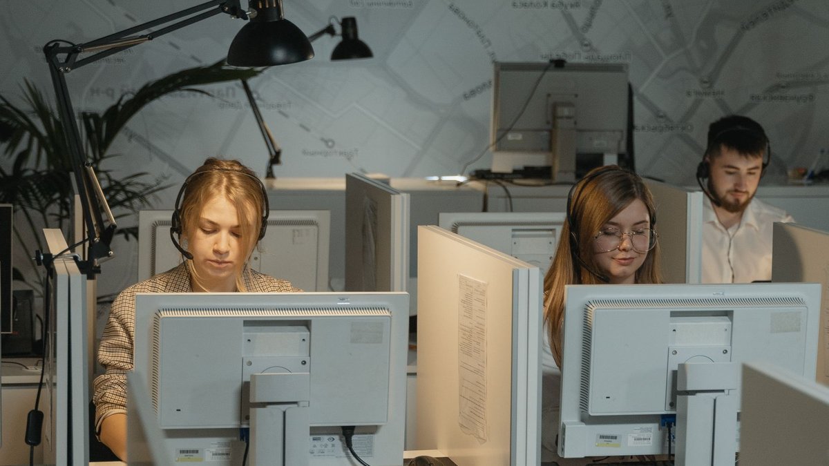 Call center agents working diligently with computers and headphones, providing customer support.