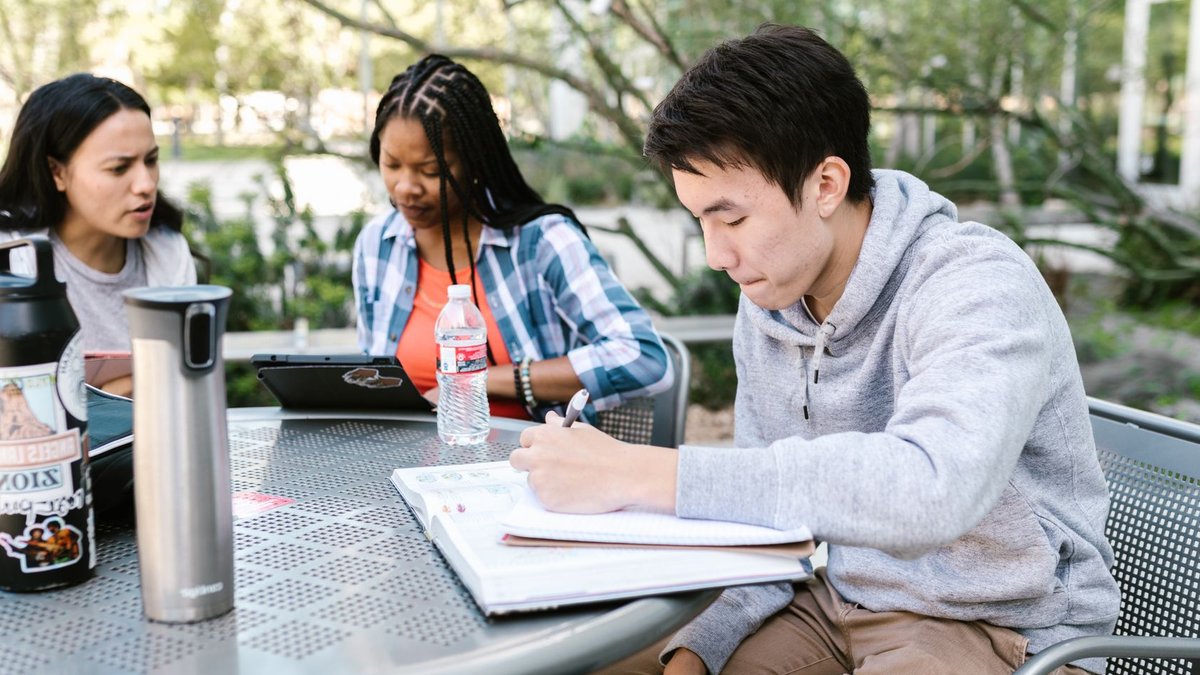Ohio University Students Handle Off-Campus Housing Challenges A diverse group of students collaborating and studying together outdoors at a college campus.