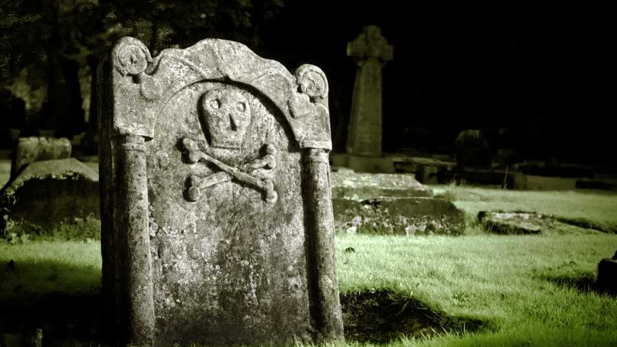 A gravestone with skull and bones.