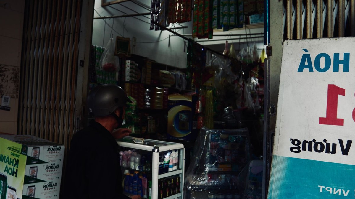 AEON Accelerates Vietnam Expansion with Four Malls A local convenience store in Vietnam with a customer browsing products.
