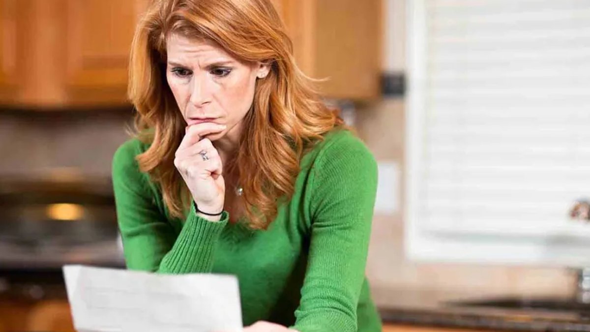 Worried woman looking at paperwork.