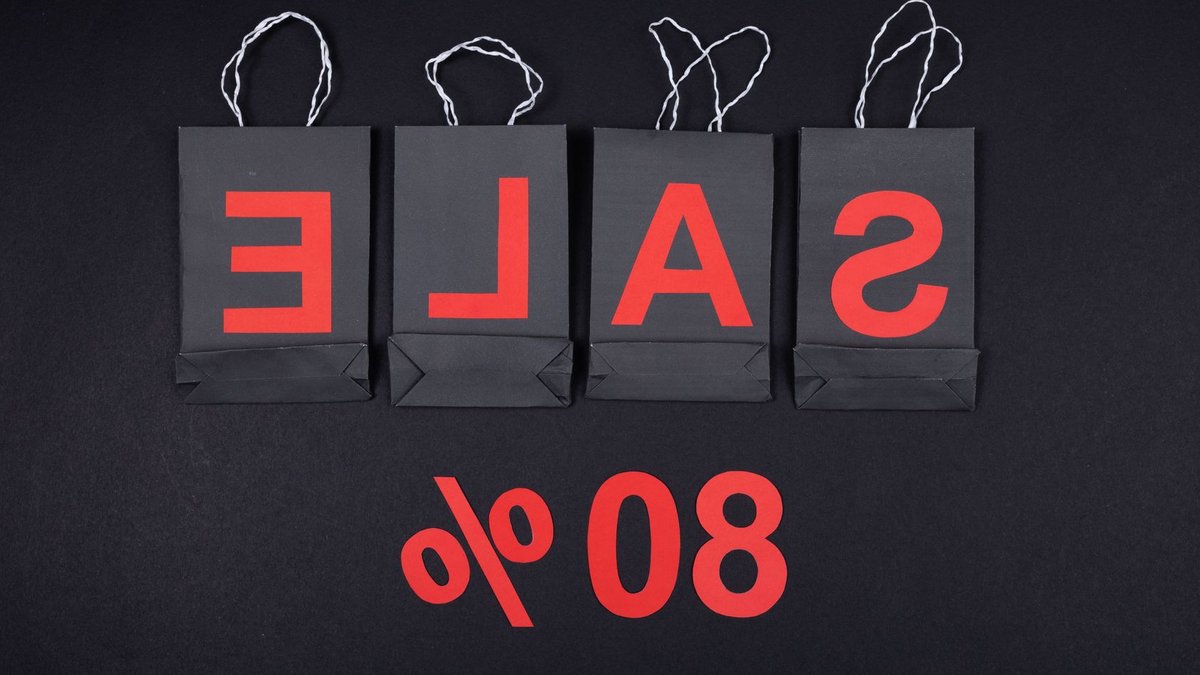 Highlighting a sale with 80% discount using black shopping bags and bold red text.