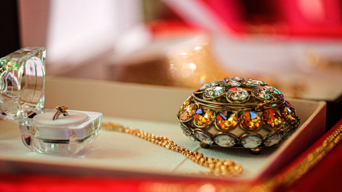 NYC Jewelry and Antique Show Returns This November Close-up of a luxurious jewelry box with exquisite gold and jeweled accessories in an elegant display.