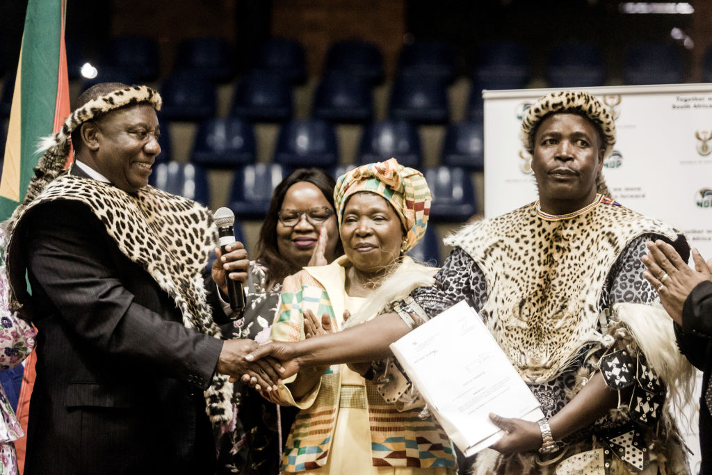 South African President Cyril Ramaphosa (L) hands over the title land deeds to Inkosi (Chief ) Mandla Mkwanazi of the KwaMkwanazi community/ Getty Image