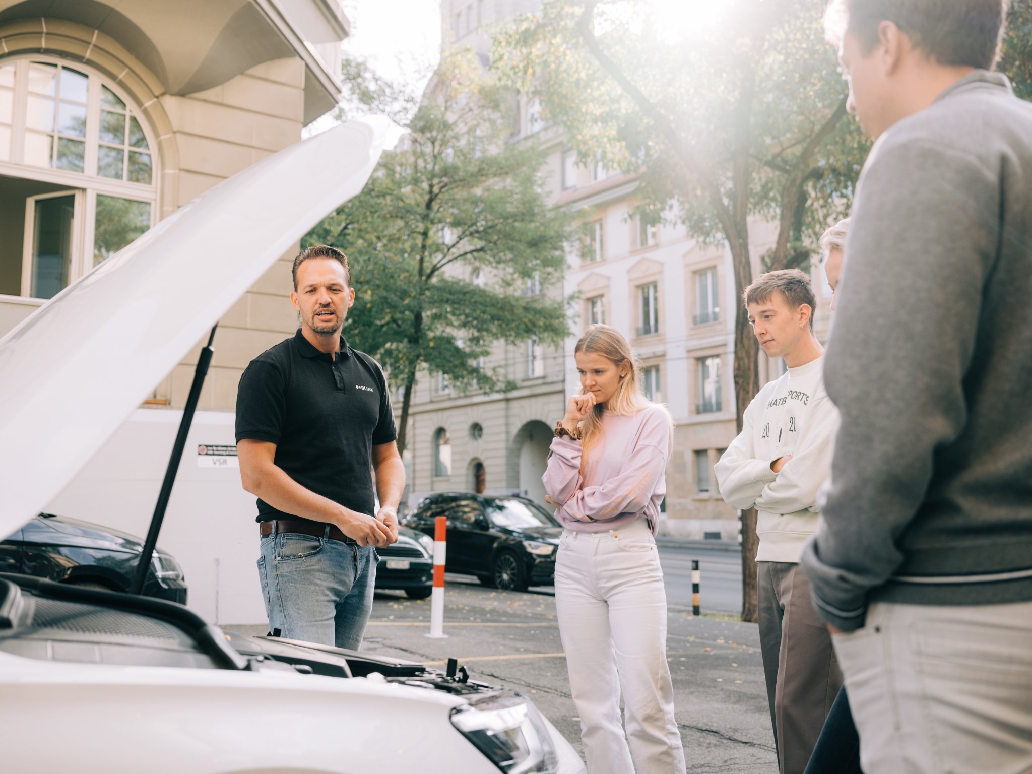 Ein Fahrlehrer erklärt den Kursteilnehmer:innen im VKU Frauenfeld, wie der Ölstand bei einem Auto gemessen werden kann.