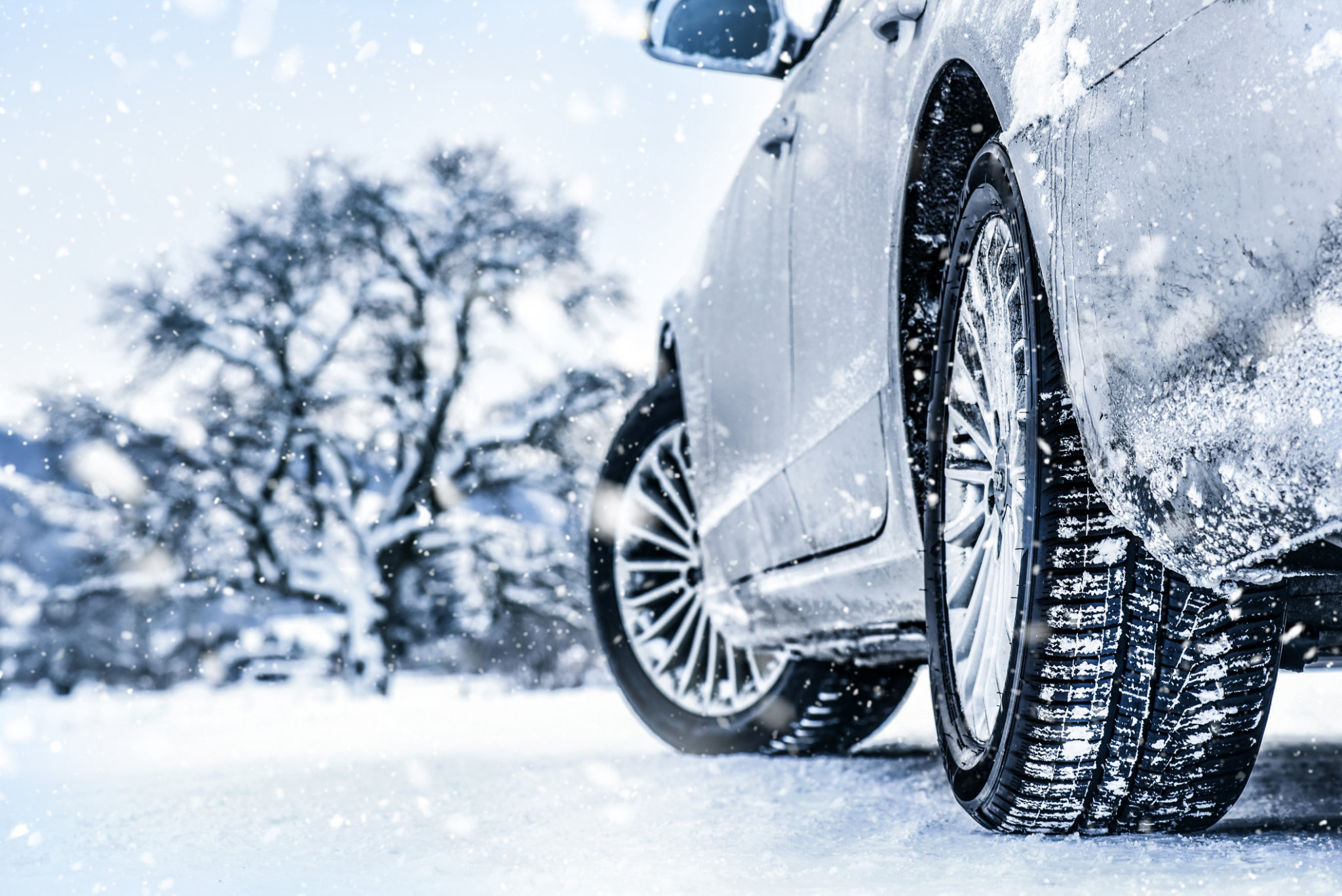 Auto mit Winterpneus auf verschneiter Strasse in der Schweiz