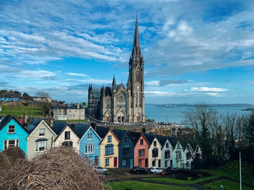 Casas coloridas na Irlanda com igreja de fundo