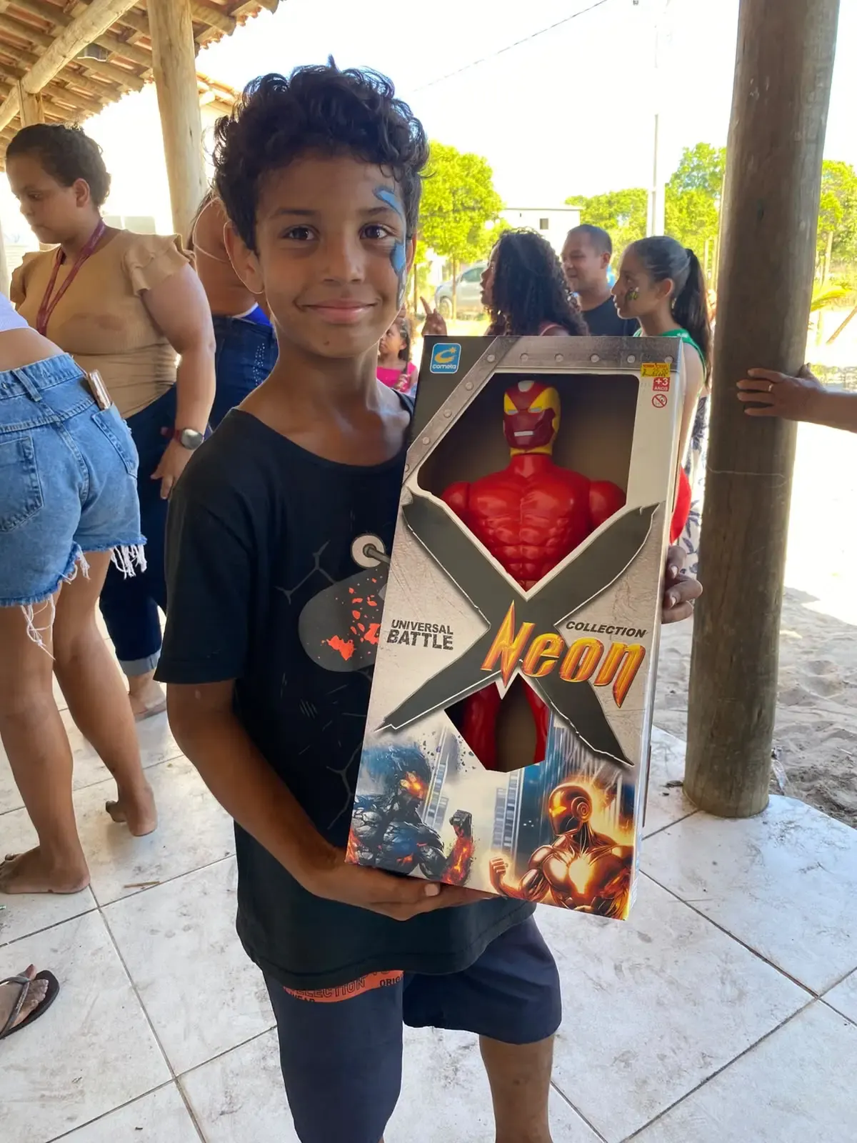 Criança segura brinquedo durante ação na Aldeia Novos Guerreiros