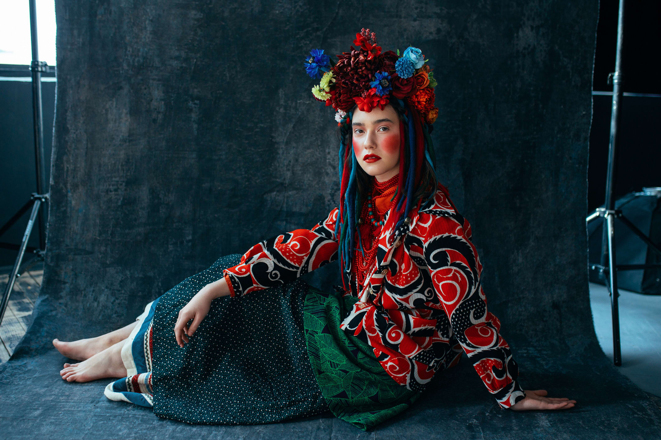 A person in vibrant traditional clothing with a floral headdress