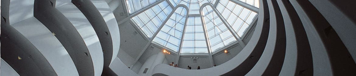 Interior view looking up at a large glass dome ceiling with a geometric grid pattern. Curved