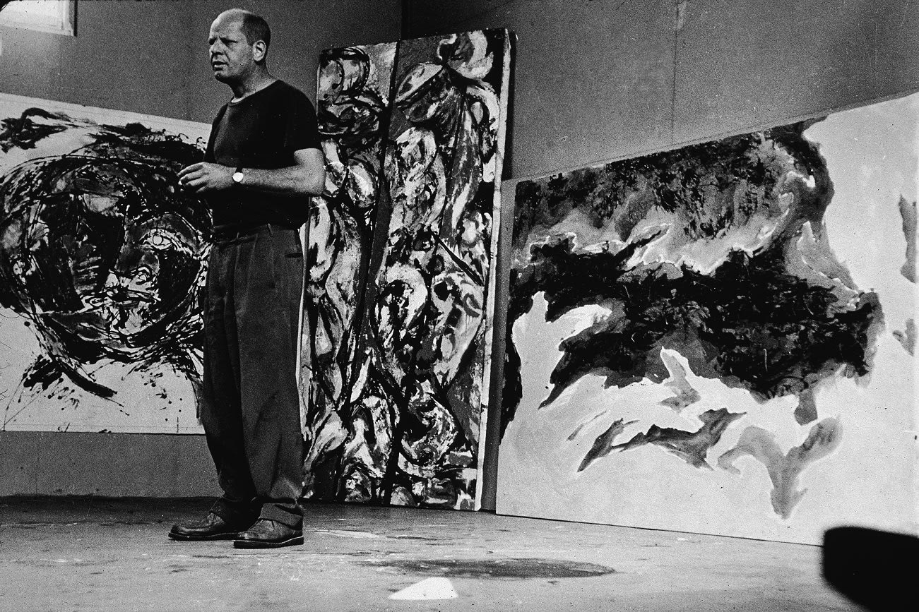 American abstract expressionist painter Jackson Pollock (1912 - 1956) stands amid some large paintings in his studio at 'The Springs,' East Hampton, New York, August 23, 1953. (Photo by Tony Vaccaro/Getty Images)