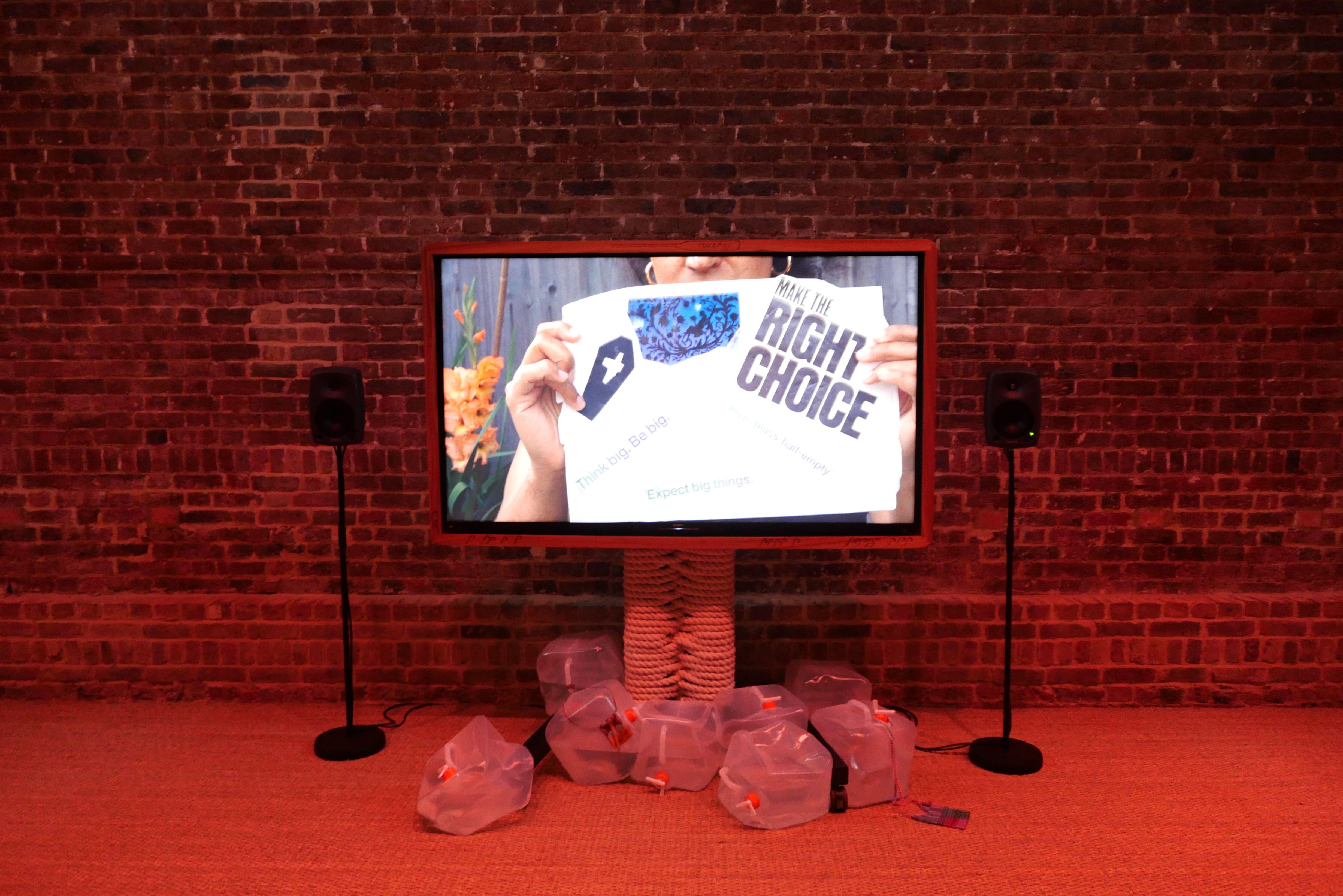 Art installation showing a large screen mounted on a brick wall