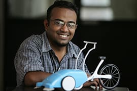 Photograph of Subhodh R. Morey with his design of a street cleaning machine