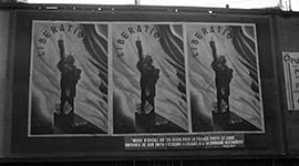 Photo of large posters on a wall with text saying 'Liberation'