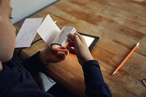 Child using a lightbox to draw on paper to make a flip book