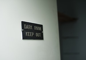 'Dark Room Keep Out' sign on brick wall