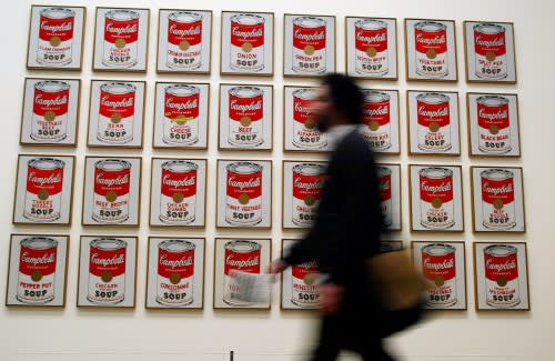 A spectator walks past 'Campbells Soup Cans' created in 1962 by artist Andy Warhol.