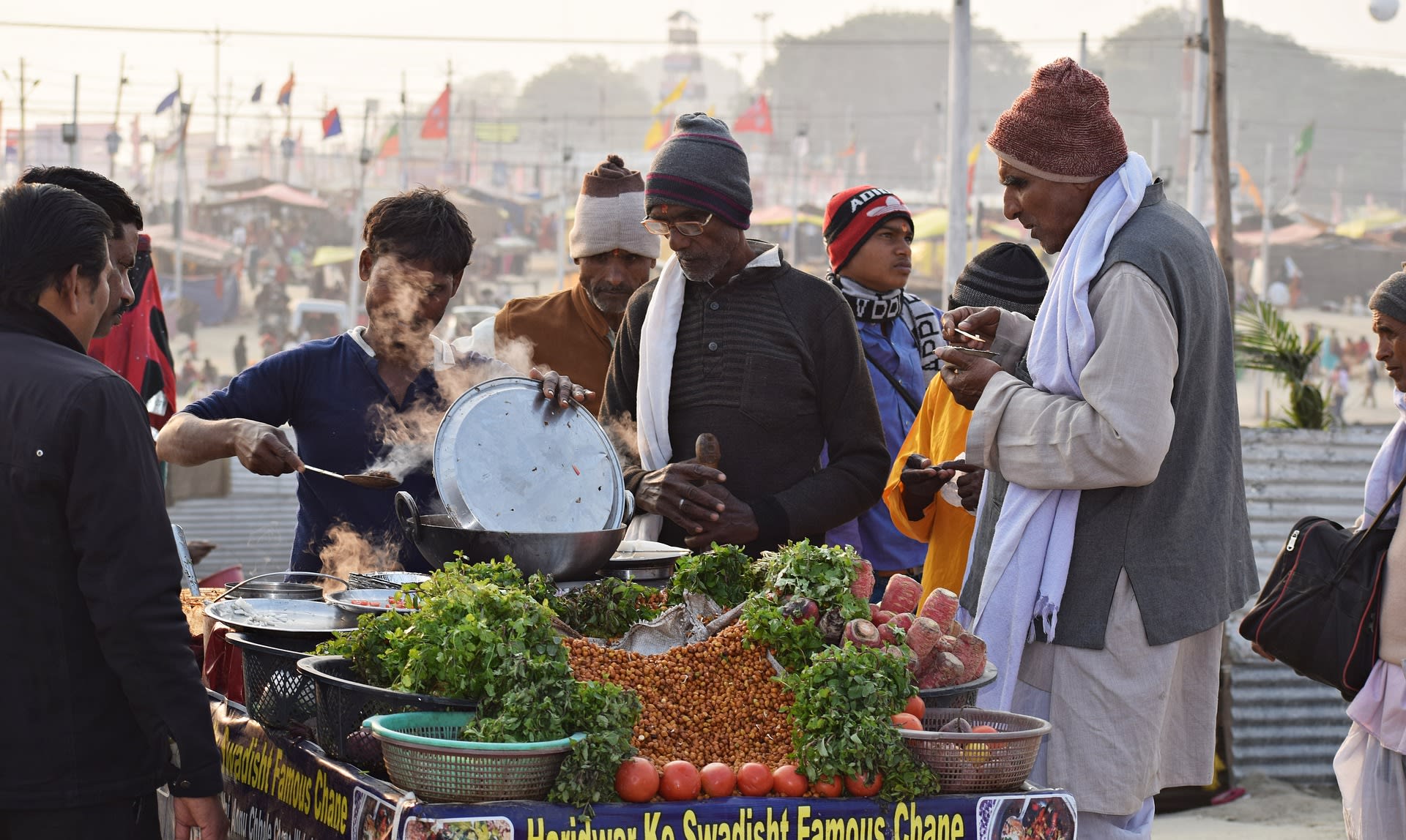 A food stall selling fruit with people gathered around it (Pixabay)