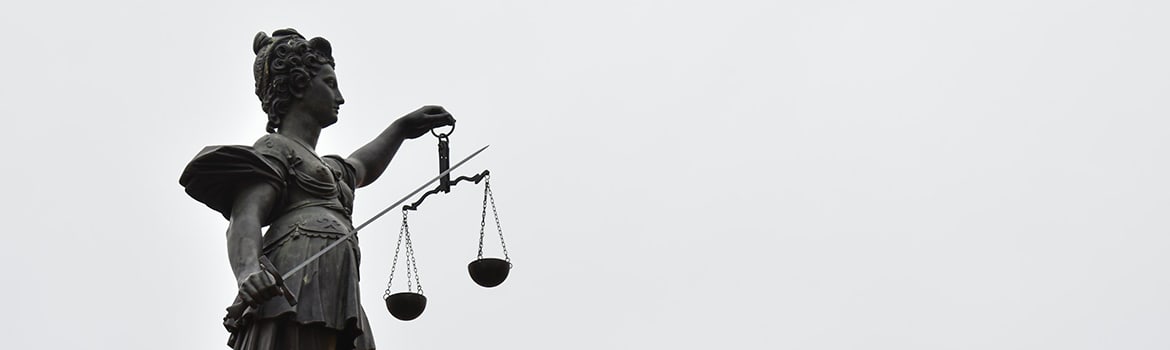 A statute of Justice with scales in one hand and a sword in the other