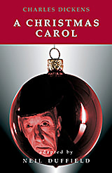 Scrooge's face is reflected in a Christmas ornament on the front cover of A Christmas Carol by Charles Dickens