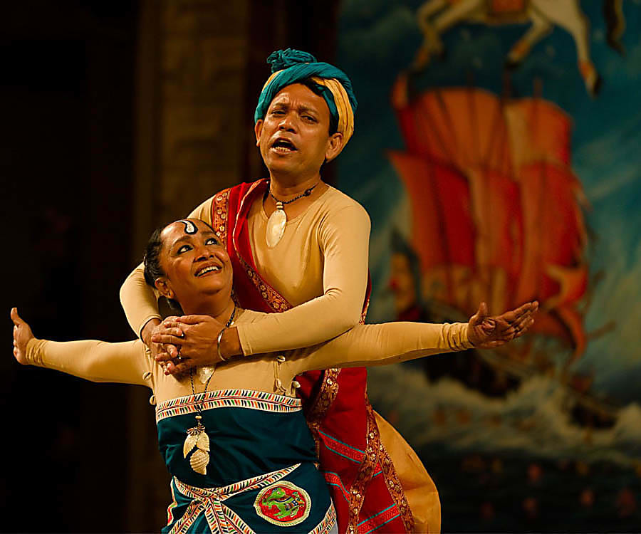 Two actors on stage performing in the production The Tempest in the language Bangla at Shakespeare's Globe Theatre, London