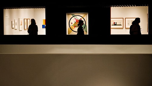 Bauhaus exhibition A woman passes circles in a circle by russian painter Wassily Kandinsky on the wall of barbican centre