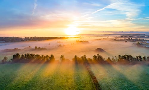 Colorful sunrise on a foggy day over Tipperary mountains and fields