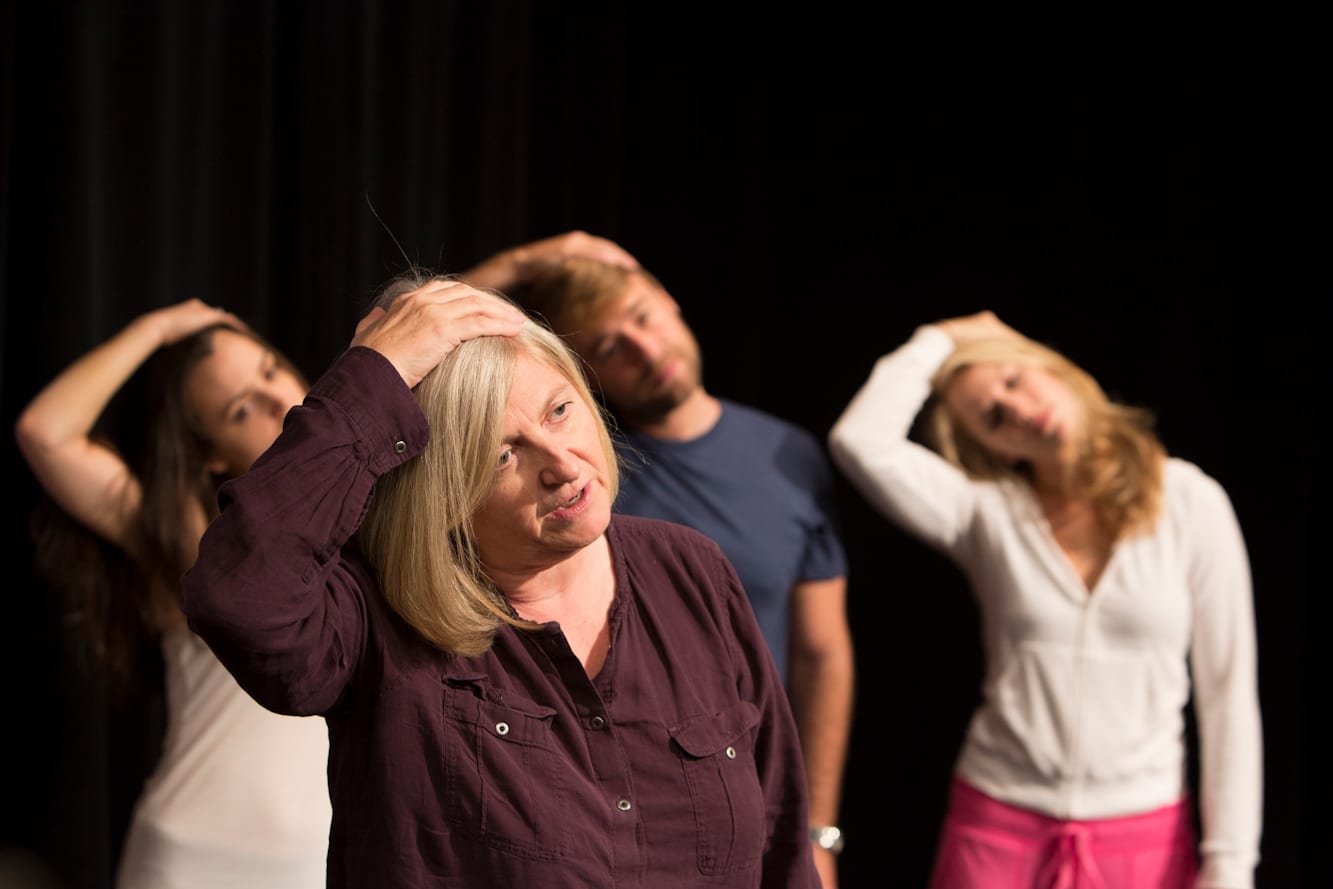 Patsy Rodenburg leads students in an exercising stretching their neck