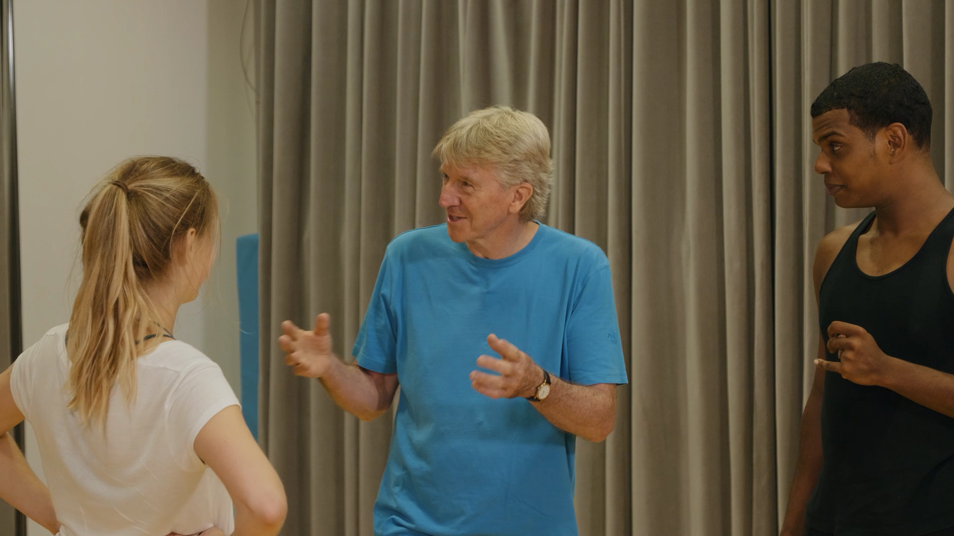 Ken Rea smiling during a teaching session with two students