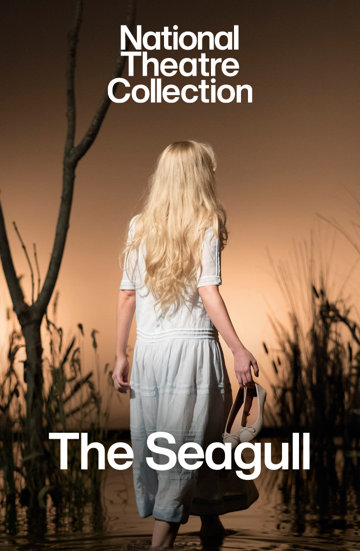 An actress with blonde hair in a light blue dress walking in the river, her back turned away, holding her shoes. Starring in The Seagull directed by Jonathan Kent, a production recorded for the National Theatre