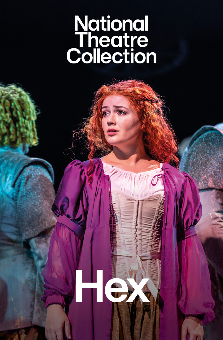 A young red haired woman in a corset and purple gown looks anguished