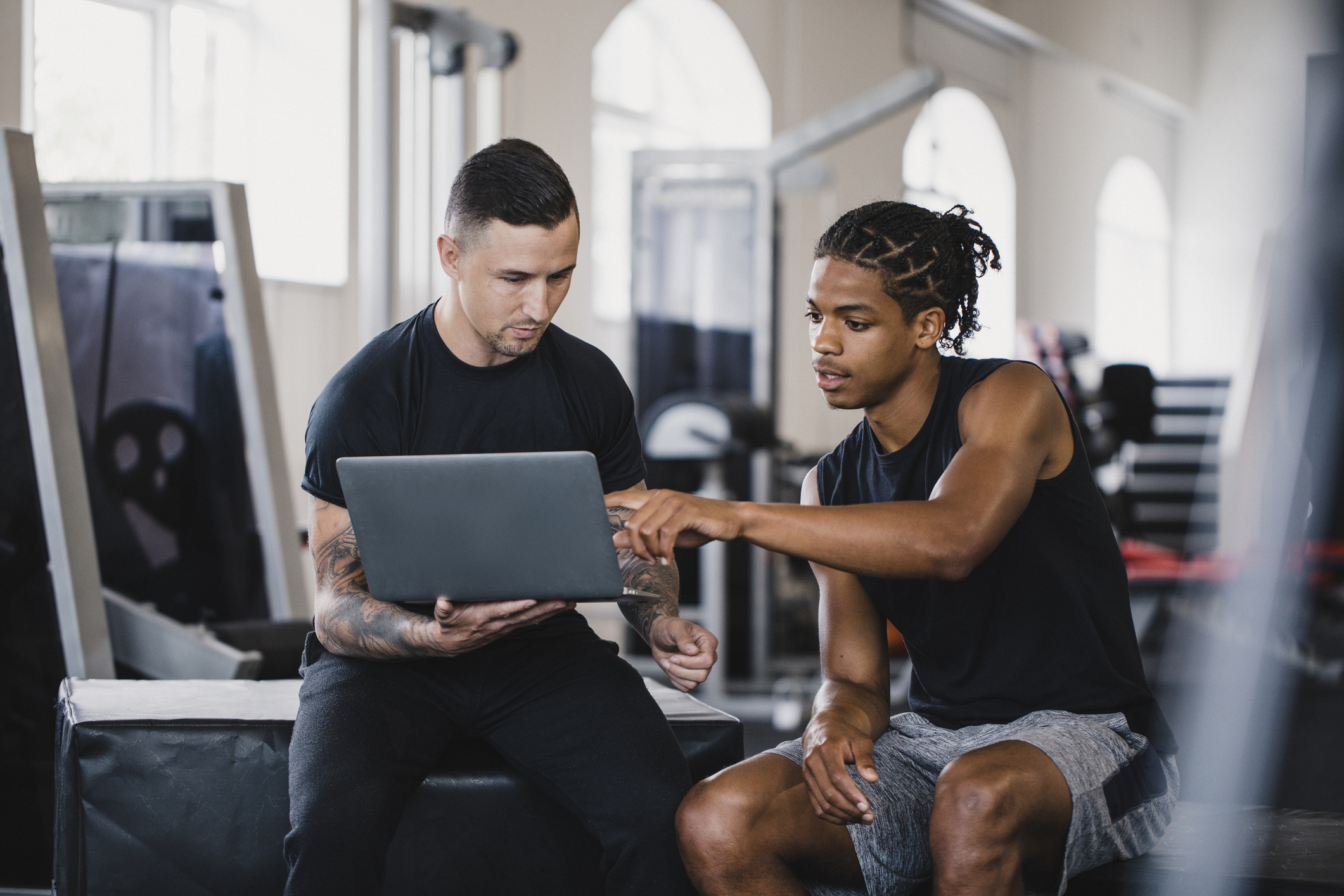two men planning strategy on a laptop