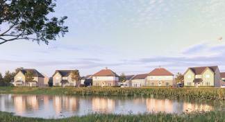 A tranquil pond with reeds in the foreground reflects a row of modern houses under a cloudy sky in the background.