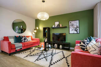 A vibrant and eclectic living room with a green accent wall, a red sofa, and a patterned rug, creating a visually striking and cozy atmosphere.