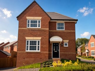 A modern brick house with a black front door stands in the foreground, while a clear blue sky with scattered clouds forms the background.