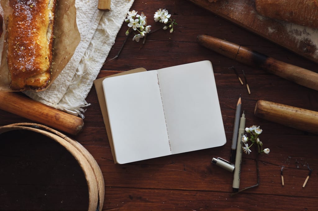 open blank journal beside bread
