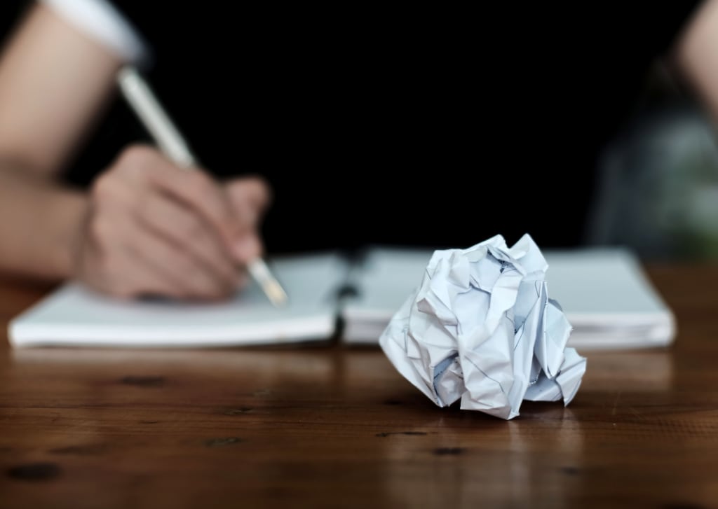 dealing with rejection as a writer by crumpling up paper and writing in notebook