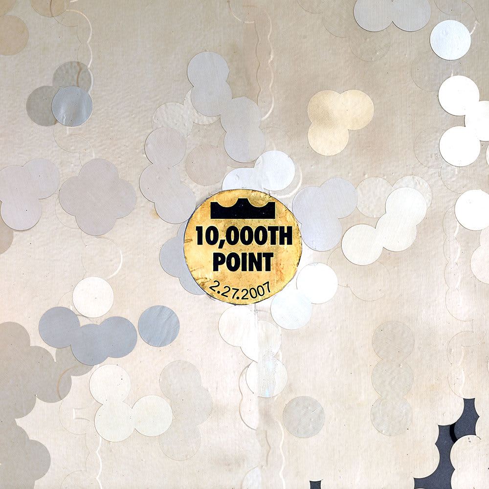 A gold circle containing the words “Ten-thousandth Point”