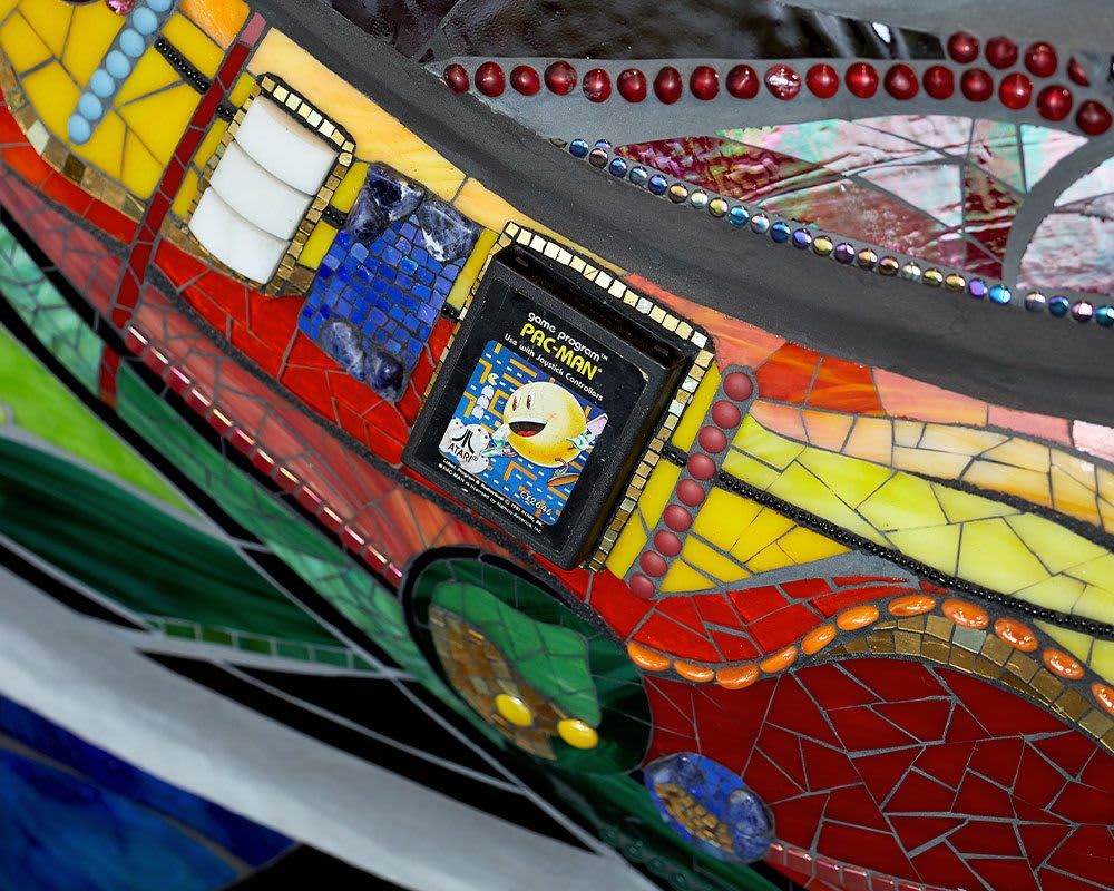 A Pacman game cartridge mounted to a wall