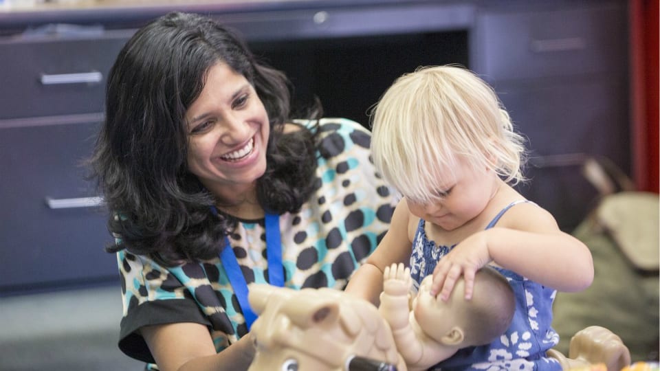 A smiling woman caring for a small child in the Blue Oaks Church Kids Ministry A smiling woman caring for a small child in the Blue Oaks Church Kids Ministry