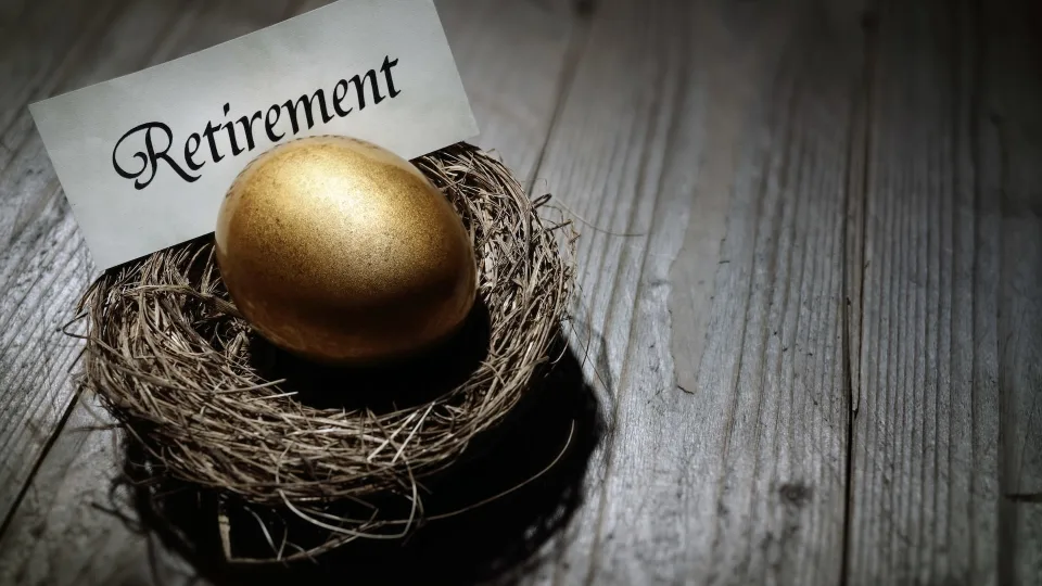 image of a golden egg in a nest on a wooden table, retirement planning