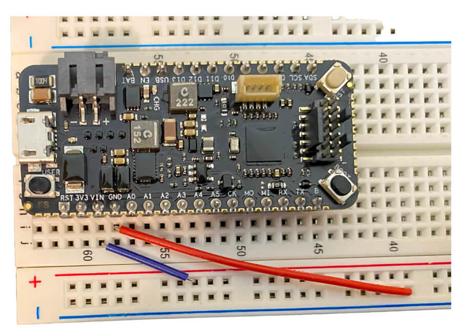 A development board sits on the breadboard, all wired up and ready to use.