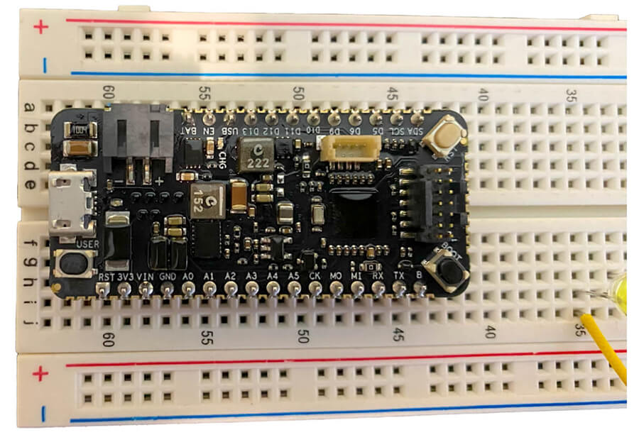 A development board straddles the breadboard divider