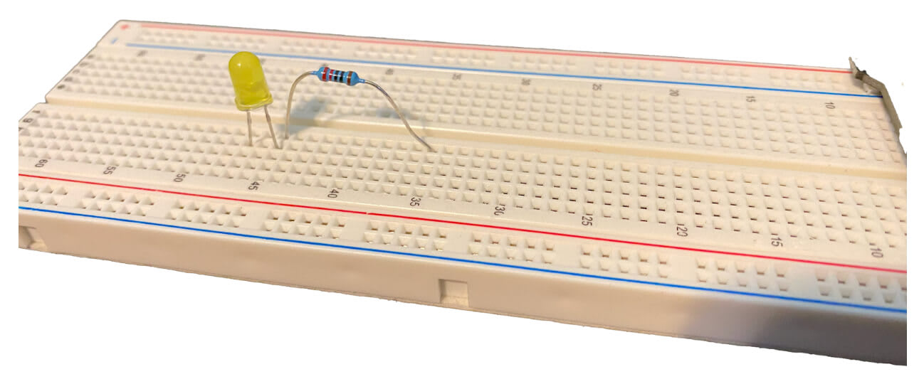 A resistor and LED light are connected to a breadboard in series