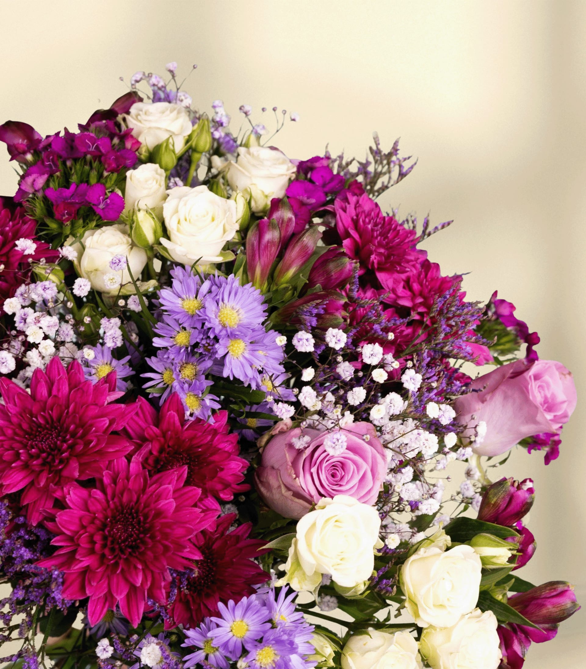 Ein farbenfroher Strauß verschiedener Blumen, darunter rosa Rosen, violette und weiße Gänseblümchen und dunkelrote Dahlien, arrangiert vor einem schlichten weißen Hintergrund.