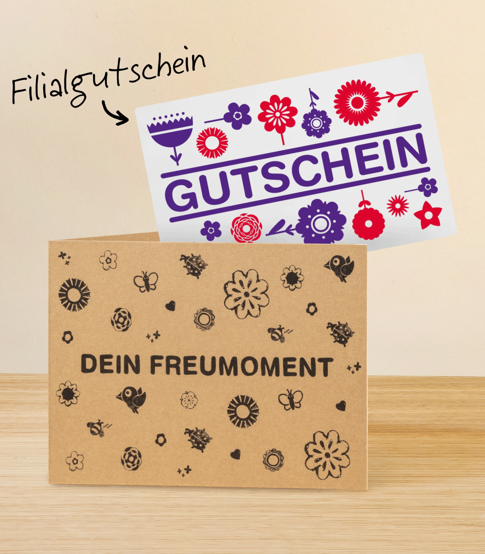 Das Bild zeigt einen Geschenkgutschein mit farbenfrohen Blumenmotiven und dem deutlich sichtbaren Wort „Gutschein“. Der Hintergrund des Bildes ist eine Holzoberfläche. (Beschreibungstext KI-generiert)