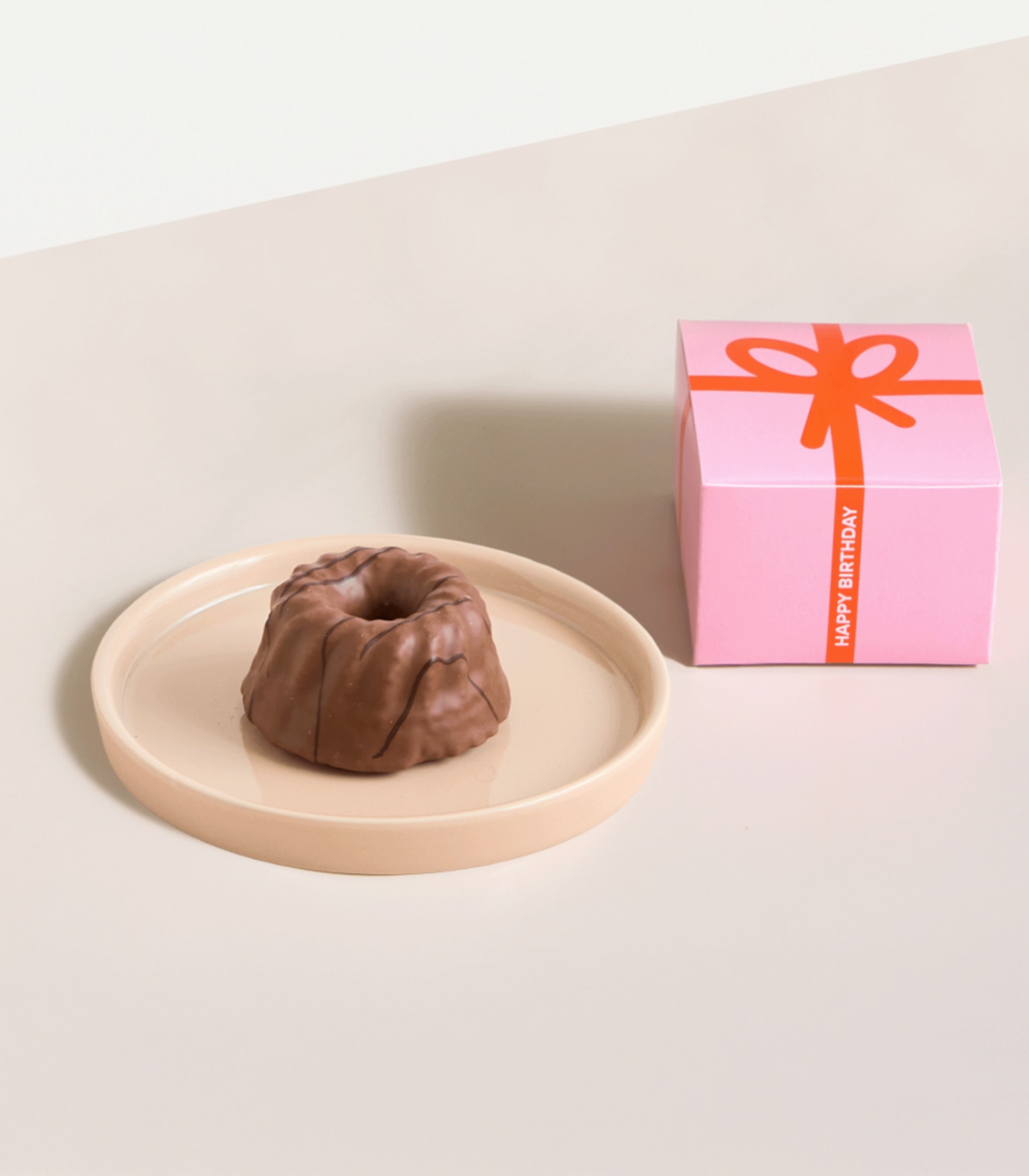 Eine Glasflasche Sekt oder Champagner mit der Aufschrift „Happy Birthday“ auf hellem Hintergrund.