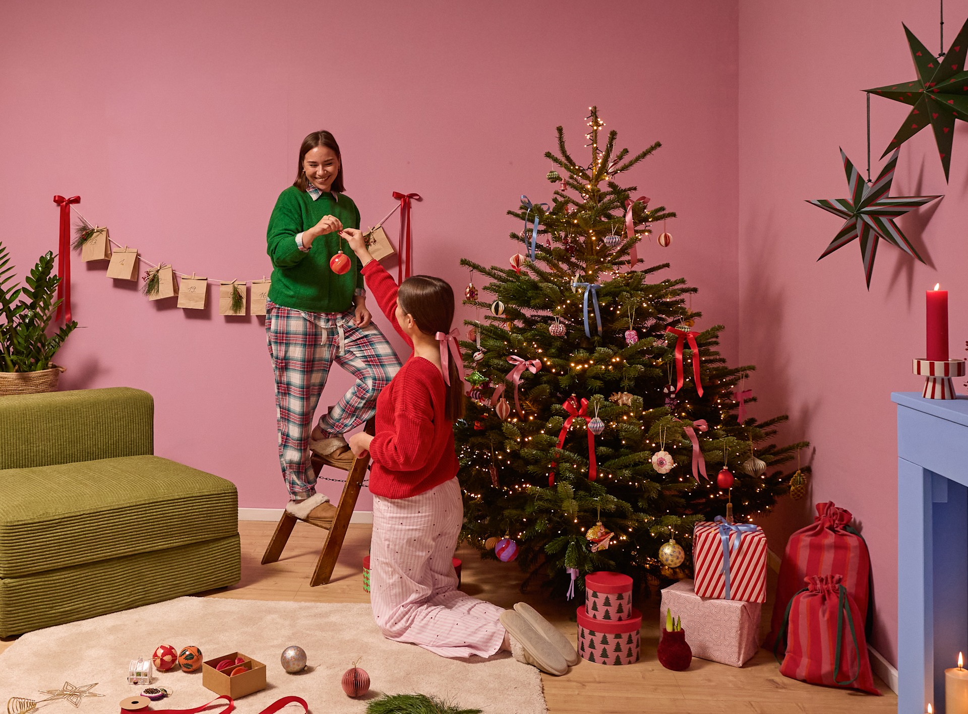 Ein festlich geschmücktes Wohnzimmer mit einem Weihnachtsbaum, Geschenken und einer Person in Weihnachtskleidung im Vordergrund.