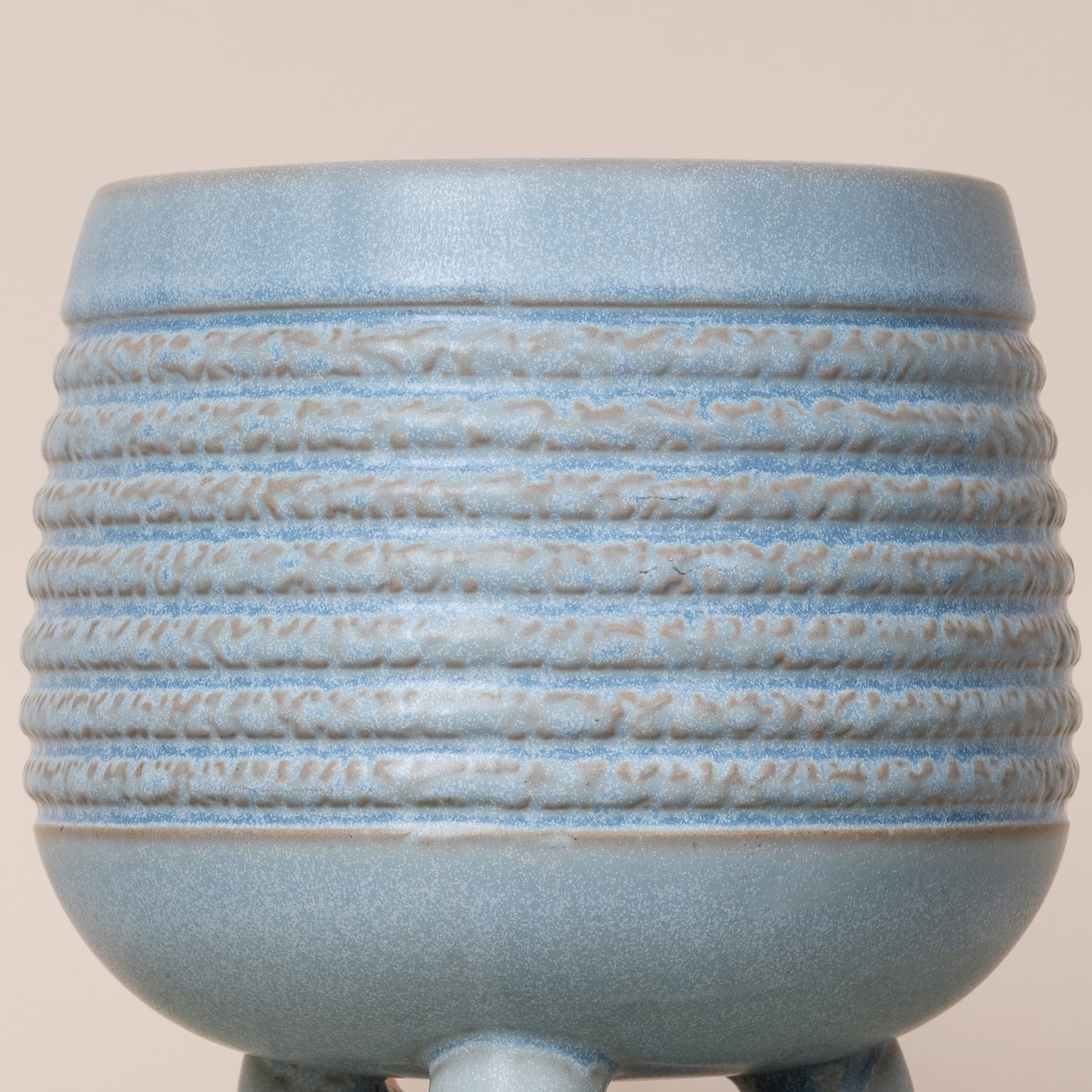 Eine hellblaue Keramikschüssel mit einem strukturierten, gerippten Muster auf der Außenfläche.