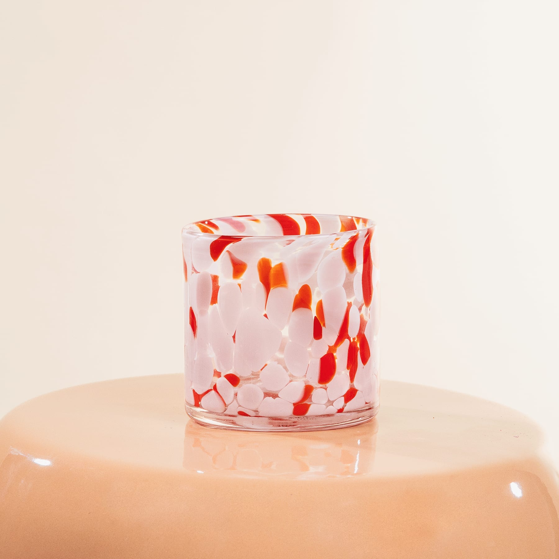 Eine Frau in einem schwarzen Kleid steht vor einem weißen Regal und betrachtet einen Dekorationsgegenstand auf einem der Regale.